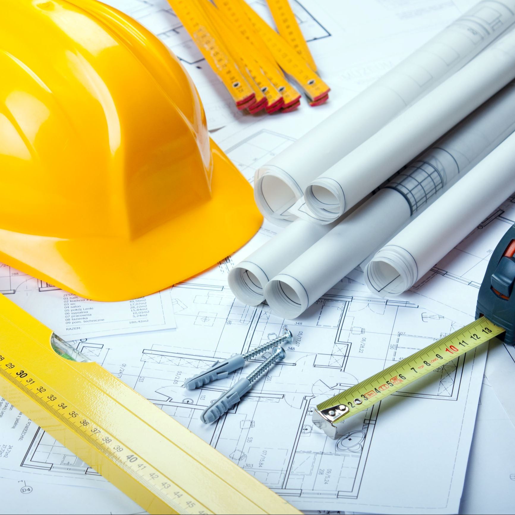 Photo of construction plans, hard hat, tape measure