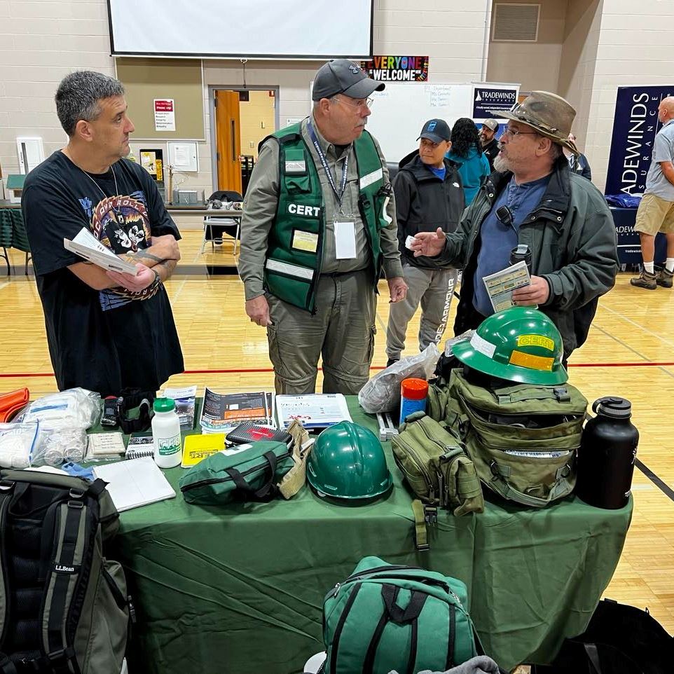 People staffing a table at a Department of Emergency Management Preparedness Fair